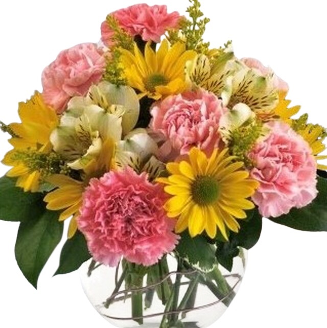 A cheerful bouquet of pink carnations, yellow daisies, and white flowers in a clear glass vase.