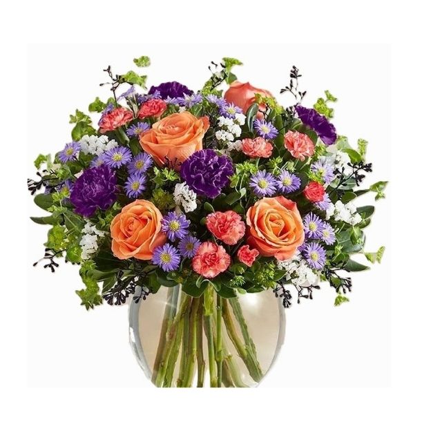Colorful floral arrangement in a clear vase featuring orange, purple, pink, and white blooms with lush greenery.